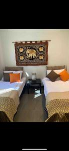 a room with two beds and a table in it at Relax and Rejuvenate in Rayong! in Rayong