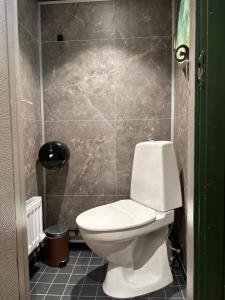 a bathroom with a toilet and a tiled wall at Den Röda Båten in Stockholm