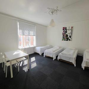 a room with three beds and a table and a window at Hotel Euroglobe in Copenhagen