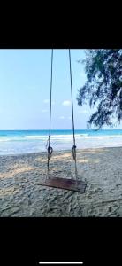 un columpio en la playa con el océano en el fondo en Relax and Rejuvenate in Rayong!, en Rayong