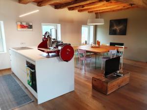 a kitchen and dining room with a table with a red appliance at Relais Poggio Pagnan in Farra