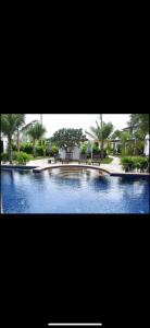 a picture of a swimming pool with chairs and trees at Relax and Rejuvenate in Rayong! in Rayong