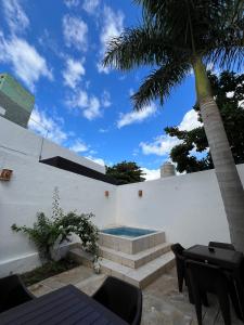a house with a swimming pool and a palm tree at Hotel Casablanca 160 in Mérida