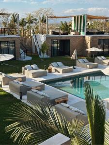 a resort with a swimming pool with chaise lounge chairs at Bora Boutique - Adults Only in Puerto Escondido