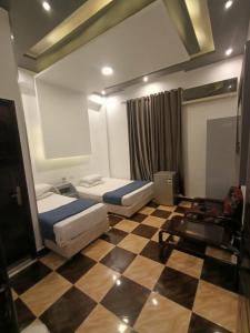 una camera con due letti e un pavimento a scacchi di Family Palace a Il Cairo