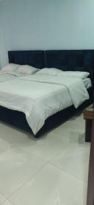 a bed with white sheets and pillows in a room at St Theresas apartment Lodge 3 in Lekki
