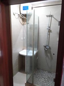y baño con ducha y lavamanos. en St Theresas apartment Lodge 3 en Lekki