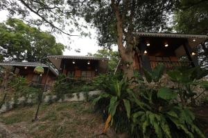 a house with a tree in front of it at NAWA Wellness in Calatagan