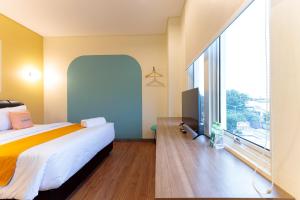 um quarto com uma cama e uma grande janela em Sans Hotel Kelapa Gading Jakarta em Jakarta