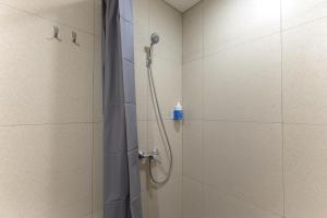 um chuveiro na casa de banho com uma garrafa azul na parede em Sans Hotel Kelapa Gading Jakarta em Jakarta