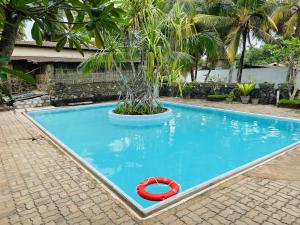 a swimming pool with a red ring in the water at Aprima Hotel in Kalutara