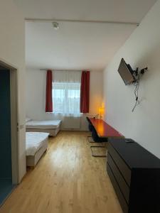 ein Wohnzimmer mit einem Schreibtisch und einem Tisch in einem Zimmer in der Unterkunft Workbase Hostel in Wien