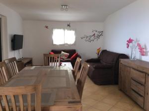 ein Esszimmer und ein Wohnzimmer mit einem Tisch und einem Sofa in der Unterkunft A la belle Etoile. Appt de charme 1er ét. villa in Saint-Leu