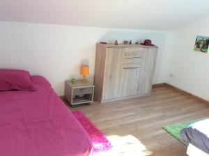 ein Schlafzimmer mit einem lila Bett und einem Schrank in der Unterkunft A la belle Etoile. Appt de charme 1er ét. villa in Saint-Leu
