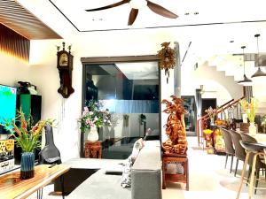a living room with a couch and a clock at The Dragon Villa Hoi An in Hoi An