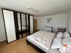 RettenbachにあるFerienwohnung To-Ni-Leのベッドルーム(ベッド1台、大きな鏡付)