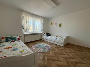 RettenbachにあるFerienwohnung To-Ni-Leのベッド2台と窓が備わる小さな客室です。