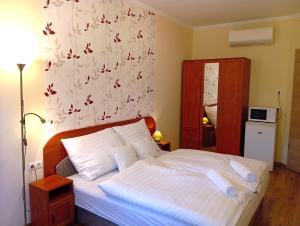ボガーチにあるPatak-Party Apartmanokの花柄の壁紙を用いた白いベッド付きのベッドルーム1室