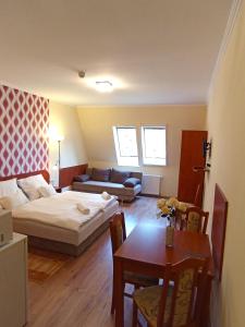 Habitación con cama, mesa y sofá en Patak-Party Apartmanok, en Bogács