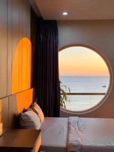 a bedroom with a window with a view of the ocean at ChanKy Hotel Dao Phu Quy in Cu Lao Thu