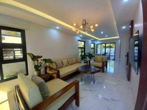 a living room with a couch and a table at Casa Ysobel, Brand New Villa near Rotunda in Tagaytay