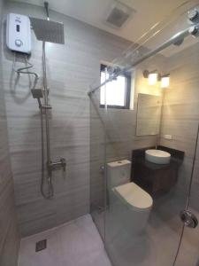 a bathroom with a shower and a toilet and a sink at Casa Ysobel, Brand New Villa near Rotunda in Tagaytay