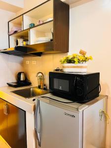 un micro-ondes au-dessus d'un réfrigérateur dans une cuisine dans l'établissement BRENT STUDIO ROOM IN TAGAYTAY WITH TAAL LAKE VIEW, à Tagaytay