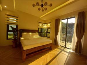 a bedroom with a bed and a large window at Casa Ysobel, Brand New Villa near Rotunda in Tagaytay