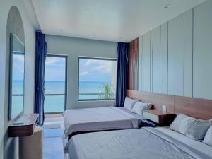 a bedroom with two beds and a large window at ChanKy Hotel Dao Phu Quy in Cu Lao Thu +23 photos