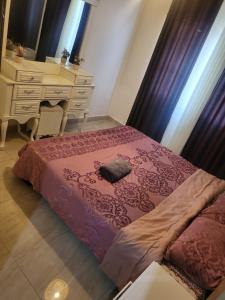 a bedroom with a bed with a dresser and a desk at اوليفيا للشقق الفندقية in Amman