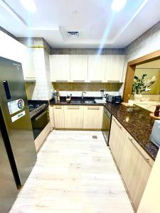 uma grande cozinha com um longo corredor no meio em Tranquil Haven Perfect Retreat for Your Holiday 510 em Abu Dhabi