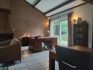 una oficina con escritorio en una habitación con una pared de ladrillo en Spacious holiday home near with sauna, en Garderen
