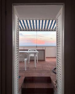 a view from the door of a patio with a table at Casa con terrazza vista 180° sulla costa orientale in Santa Cesarea Terme