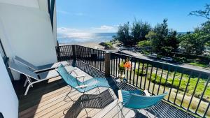 balcón con 2 sillas y vistas al océano en Résidence Santa Apolonia en Saint-Leu