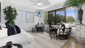 - un salon avec un canapé blanc, une table et des chaises dans l'établissement Seaside Serenity Retreat, à Bellara