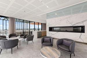 a waiting room with chairs and a fireplace at Top of the World Sky High Luxury in Newcastle