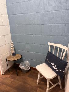 a white chair sitting next to a blue wall at The Hideaway in Fakenham
