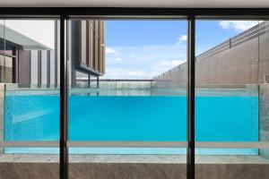 a view of a swimming pool through a window at Top of the World Sky High Luxury in Newcastle