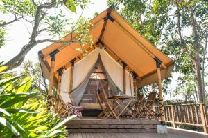uma tenda com cadeiras num deque de madeira em The Park - Silang em Silang