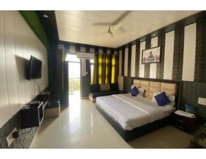 um quarto com uma cama e uma televisão em Hotel Tulsi, Rudraprayag em Rudraprayāg