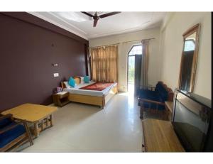 um quarto com uma cama e uma televisão num quarto em Hotel Tulsi, Rudraprayag em Rudraprayāg