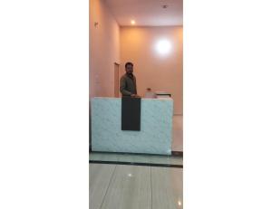 a man standing at a counter in a room at Uma Hotel, Chitrakoot in Sītāpur Mūāfi