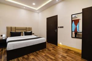 een slaapkamer met een bed in een kamer met houten vloeren bij OYO Hotel sakina in Calcutta