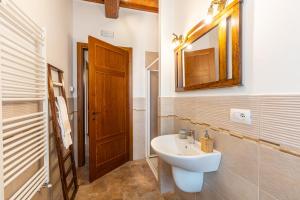 Łazienka z białą umywalką i drewnianymi drzwiami w obiekcie Agriturismo il Casato Mag-il Vaglio w mieście Pienza