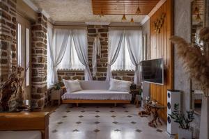 - un salon avec un canapé blanc et une télévision dans l'établissement Lithos Messolongi Paradise - A Luxurious Retreat, à Mesolongion