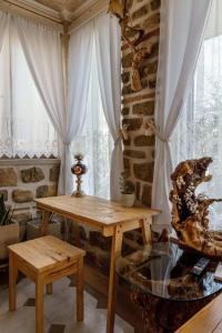 einen Tisch und einen Stuhl in einem Zimmer mit Fenstern in der Unterkunft Lithos Messolongi Paradise - A Luxurious Retreat in Mesolongi