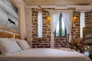 um quarto com uma cama e uma parede de pedra em Lithos Messolongi Paradise - A Luxurious Retreat em Mesolongion