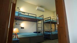 two bunk beds in a room with a lamp at The Colaba Pod in Mumbai