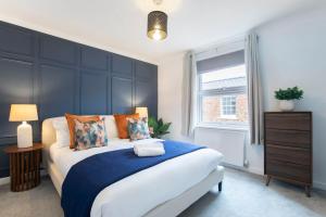 a bedroom with a large bed with a blue headboard at Beautiful Victoria Retreat in Cheltenham