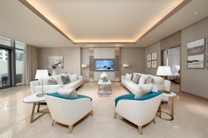 a living room with white couches and chairs at FIVE LUXE in Dubai